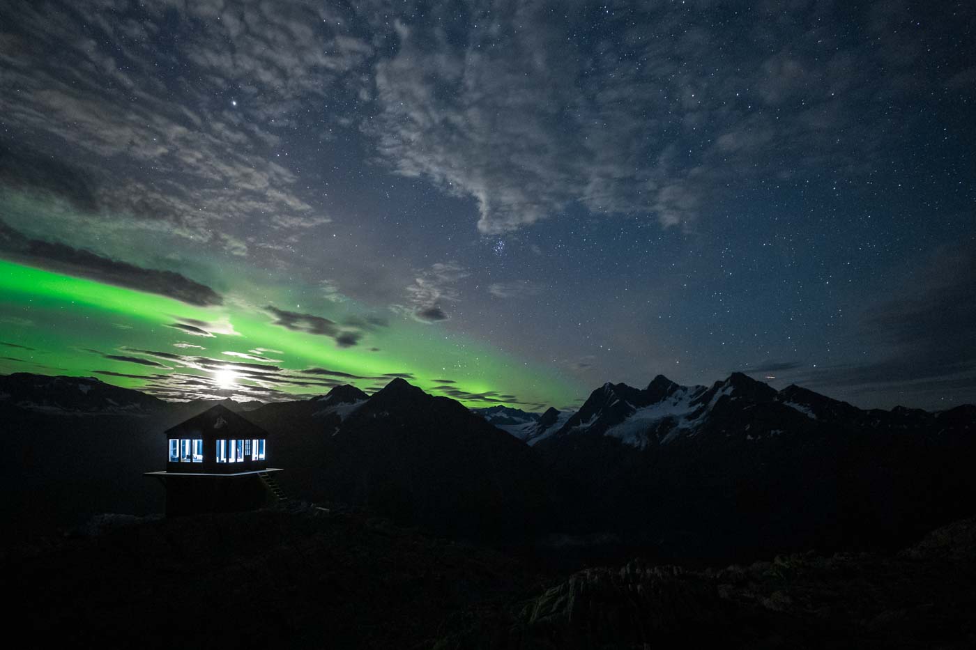 The moon above Glacier Lookout with the northern lights.