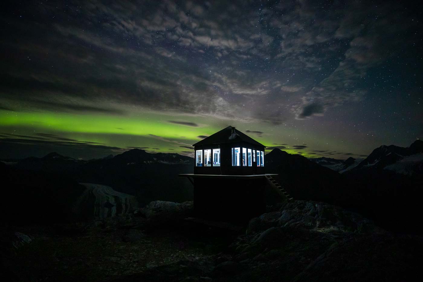 The aurora borealis glow behind Glacier Lookout
